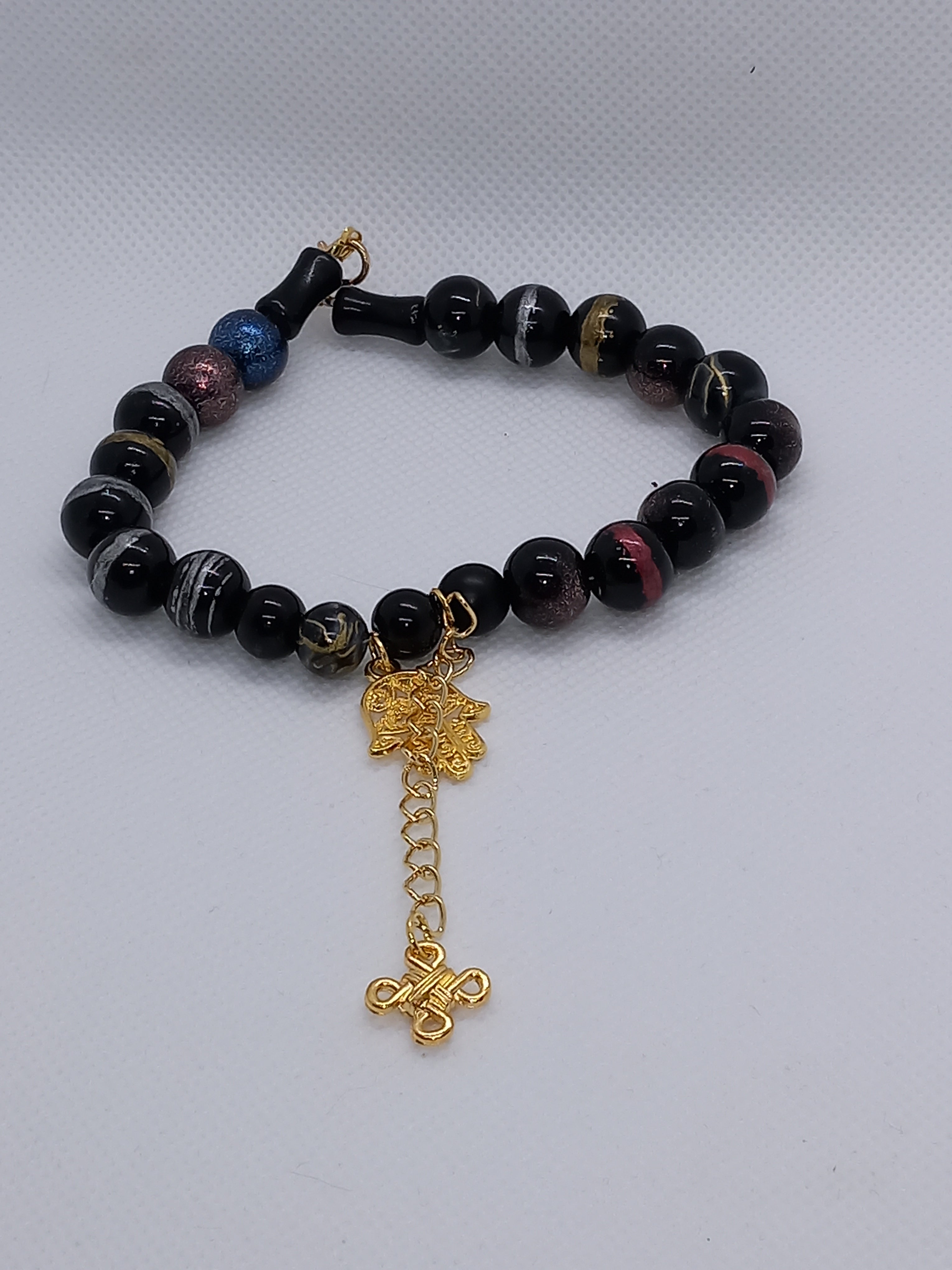 Bracelet en perles noires avec charm Hamsa doré
